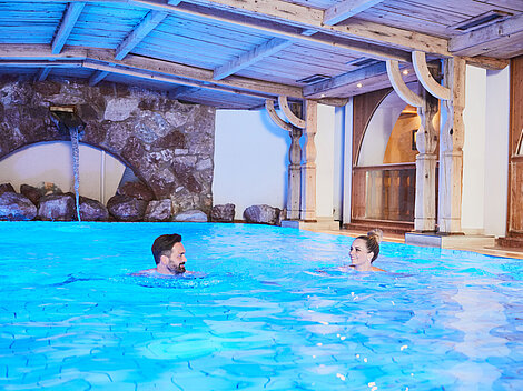 Paar schwimmt im Indoorpool