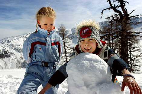 Kinder bauen Schneemann