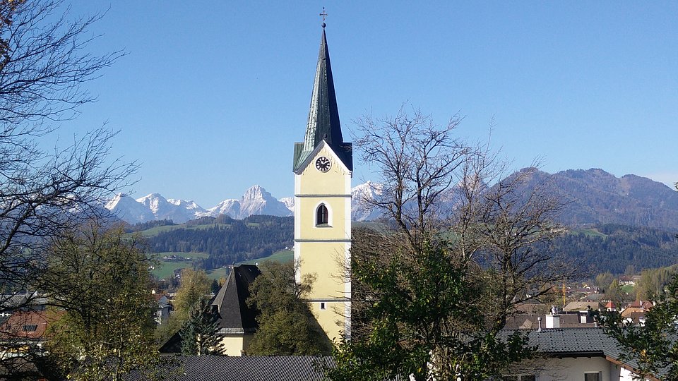 Kirche vom Pfarrheim vor blauem Himmel