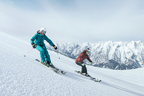 Zwei Skifahrer auf Piste