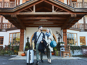 Mann und Frau schauen sich vor dem Hotel-Eingang an