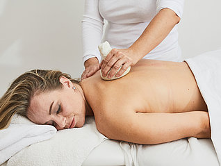 Massage mit Kräuterstempel