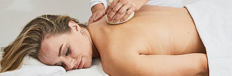 Massage mit Kräuterstempel