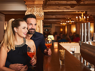 Paar an der Bar mit Gläsern Aperol-Spritz