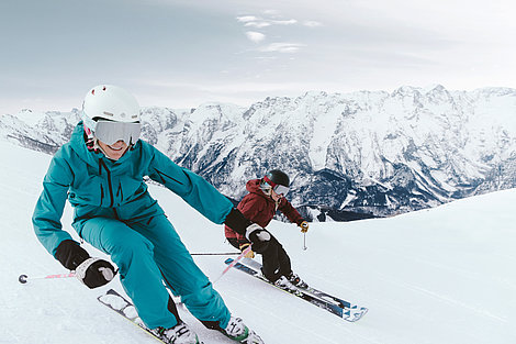 Zwei Skifahrer auf Piste