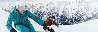Zwei Skifahrer auf Piste