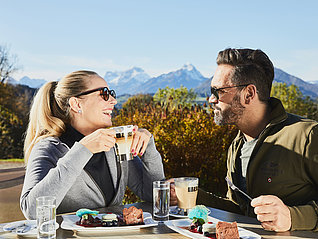 Paar bei Frühstück vor Bergkulisse
